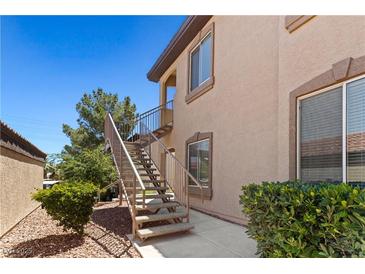Building exterior featuring a staircase, small balcony, desert landscaping and neutral color scheme at 3360 Cactus Shadow St # 203, Las Vegas, NV 89129