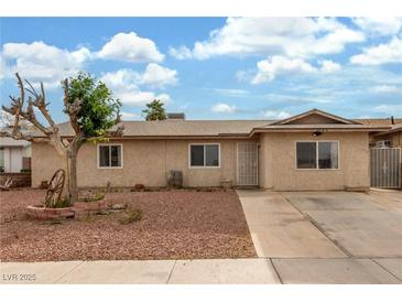 Charming single-story home featuring desert landscaping, a long driveway, and secure gated access in the front at 5109 Gains Mill St, Las Vegas, NV 89122