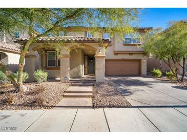 Inviting two-story home with a covered porch, a two car garage, and xeriscaped front yard at 7520 Fontera Ct, Las Vegas, NV 89139