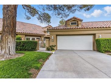 Charming single-story home featuring a two-car garage, tile roof, and mature landscaping at 7988 Harbour Towne Ave, Las Vegas, NV 89113