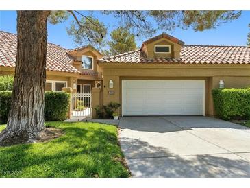 Charming home with a red tile roof, manicured lawn and lush landscaping at 7988 Harbour Towne Ave, Las Vegas, NV 89113