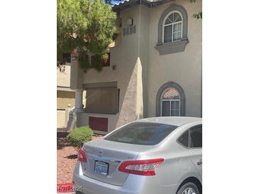 Tan apartment complex with trimmed tree in the foreground and a gray car at , Las Vegas, NV 89108