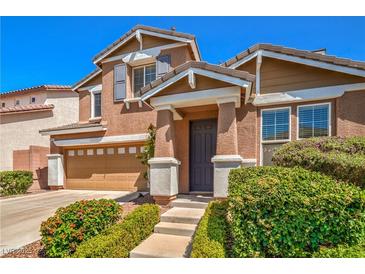 Inviting two-story home with a well-manicured lawn and an attached two-car garage at 10116 Nash Peak Ave, Las Vegas, NV 89166