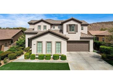 Charming two-story home with a manicured lawn and an attached two-car garage at 11 Morninglow Pass, Henderson, NV 89052