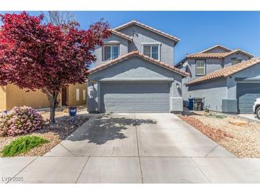 Charming two-story home features a well-maintained front yard with mature landscaping and a two-car garage at 11739 Village Arbor St, Las Vegas, NV 89183