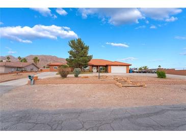Charming single-story home featuring desert landscaping, a spacious driveway, and mountain views at 120 N Phyllis St, Las Vegas, NV 89110