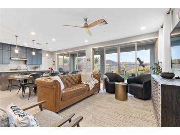 Bright, open living space featuring a neutral color palette and sliding doors with mountain views at 14 Parco Fiore Ct, Henderson, NV 89011