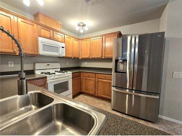 Well-equipped kitchen featuring stainless steel refrigerator and matching appliances at 4675 Basilicata Ln # 103, North Las Vegas, NV 89084