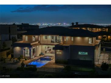 Night shot of a modern two-story home featuring a pool, jacuzzi, and views of the Las Vegas Strip at 5 Crystal Tree Pass, Henderson, NV 89052