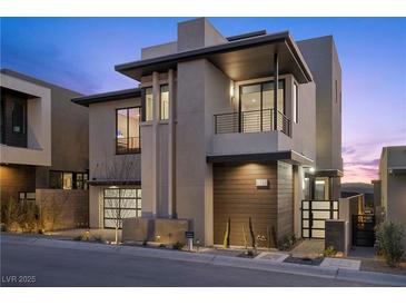 Modern two-story home featuring sleek design, wood accents, a balcony, and manicured landscaping at 577 Overlook Rim Dr, Henderson, NV 89012