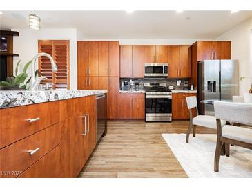 Modern kitchen featuring granite countertops, stainless steel appliances, and wood cabinetry at 9050 W Tropicana Ave # 1102, Las Vegas, NV 89147