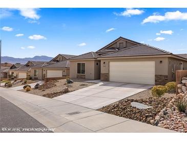 Charming single-story home featuring desert landscaping, a tile roof and an attached two-car garage at 942 Shadow Hawk Rdg, Mesquite, NV 89027