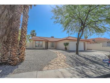 Charming single-story home featuring a tile roof, desert landscaping, and a stone walkway leading to the front door at 134 Saint Albans Dr, Henderson, NV 89015