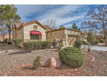 Charming home with well-maintained landscaping, a red-tile roof, and a two-car attached garage at 2520 Palmridge Dr, Las Vegas, NV 89134