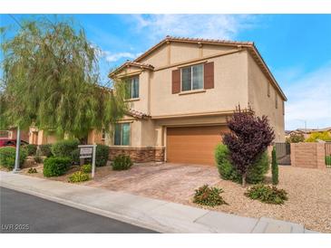 Two-story home featuring a brown two-car garage and a well-manicured lawn with beautiful landscaping at 3746 Asia Rd, North Las Vegas, NV 89032