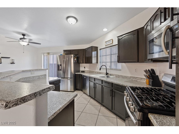 Modern kitchen featuring stainless steel appliances and dark cabinetry with granite countertops at 5184 Mineral Lake Dr, Las Vegas, NV 89122