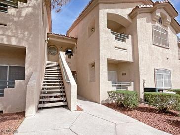 A three-story condo features stairs, balconies and landscaped yard with mulch in a desert setting at 5415 W Harmon Ave # 2048, Las Vegas, NV 89103
