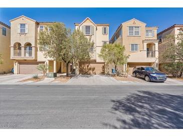 Inviting exterior of townhomes featuring desert landscaping and attached garages at 7363 San Pablin St, Las Vegas, NV 89139