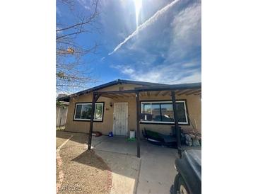 Cozy single-story home featuring a covered front porch and well-lit windows at 851 W Carey Ave, North Las Vegas, NV 89030