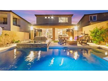 Inviting backyard pool with an outdoor kitchen and lounge area for relaxation and entertaining at twilight at 12430 Foxtail Run Ave, Las Vegas, NV 89138