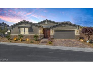 Charming single-story home boasts desert landscaping, a two-car garage and a neutral color palette at 2489 Cingoli St, Henderson, NV 89044