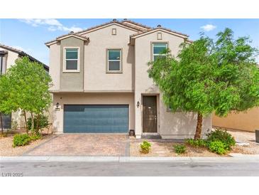 Charming two-story home with desert landscaping and a blue garage door at 2672 Painted Mist Ct, Las Vegas, NV 89142
