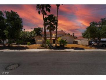 Charming home with mature trees, palm trees, and a long driveway leading to the attached two-car garage at 3341 Heavenly View Ct, Las Vegas, NV 89117