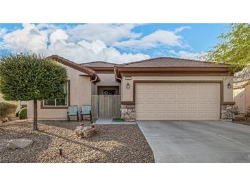 Charming home featuring desert landscaping, a two-car garage, and quaint seating near the front door at 7927 Crested Starling Ct, North Las Vegas, NV 89084