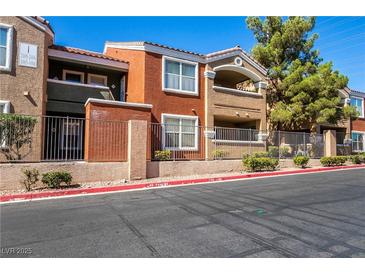 Multi-colored condo building with wrought iron fencing and lush green landscaping at 8101 W Flamingo Rd # 2006, Las Vegas, NV 89147