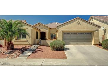Inviting single-story home featuring a well-maintained front yard, desert landscaping and attached two car garage at 8129 Jim Steele Falls St, North Las Vegas, NV 89085