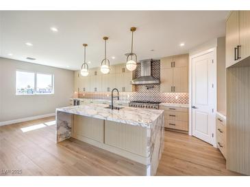Modern kitchen featuring a marble waterfall island, stainless steel appliances, and stylish pendant lighting at 8316 Broad Peak Dr, Las Vegas, NV 89131