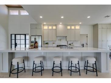 Modern kitchen with stainless steel appliances, ample counter space, and five barstool chairs at 9520 Sundial Dr, Las Vegas, NV 89134