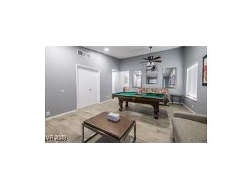 Bright game room features a pool table, neutral paint, ceiling fan, and wood-style tile flooring at 1012 Greystone Dr, Las Vegas, NV 89108
