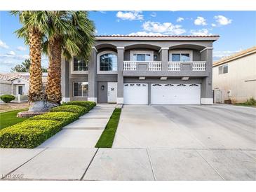 Charming two-story home with a three car garage, lush landscaping, and inviting curb appeal at 1680 Sweet Pea Ave, Las Vegas, NV 89183