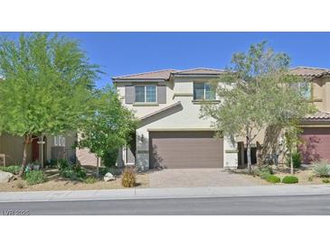 Charming two-story home featuring a tile roof, neutral stucco, a two-car garage, and desert landscaping at 2228 Sky Island Dr, Henderson, NV 89002