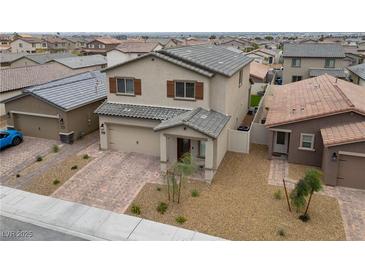 Two-story home featuring a well-kept yard, paired garage, and neutral colors at 2729 Pavehawk Way, Las Vegas, NV 89156