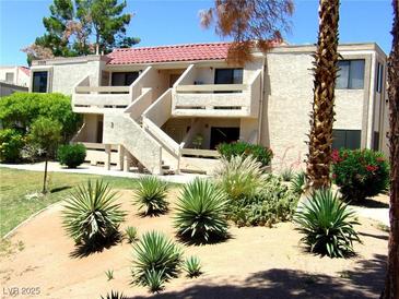 Two-story stucco condo with red tile roof and desert landscaping on a sunny day at 3720 Desert Marina Dr # 33, Laughlin, NV 89029