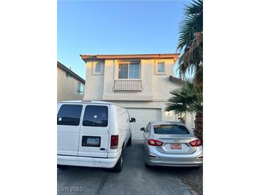 Two-story home with desert landscaping, white garage door, and two parked cars in the driveway at 4363 Pittsfield St, Las Vegas, NV 89115
