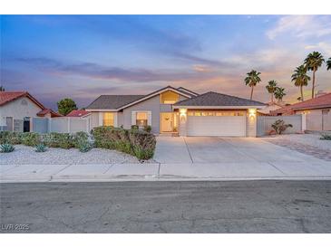 Charming single-story home featuring a two-car garage, desert landscaping, and welcoming curb appeal at twilight at 58 Pleasant Dale Dr, Henderson, NV 89074