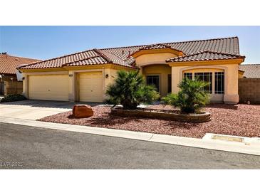 Charming home with a tile roof, three-car garage and desert landscaping, providing a welcoming curb appeal at 6016 Bungalow Bay St, Las Vegas, NV 89130