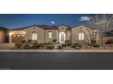 Charming single-story home featuring a tile roof, arched windows, manicured landscaping, and a two-car garage at 6333 Orto Vaso Ave, Las Vegas, NV 89131
