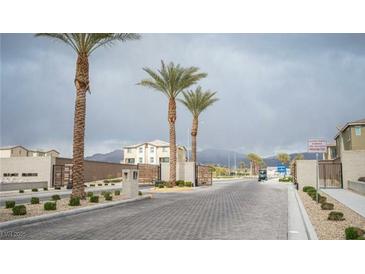 Gated community entrance featuring palm trees and well-maintained landscaping in a desert environment at 2761 Frosted Teal Ave, North Las Vegas, NV 89086
