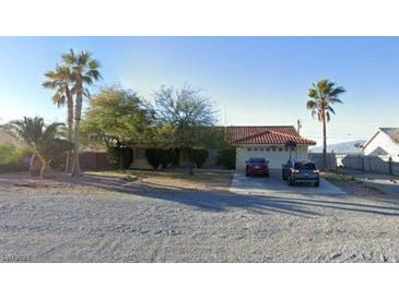 Cozy single-story home featuring a red tile roof, two-car garage, and well-maintained landscaping at 3481 Winery Rd, Pahrump, NV 89048