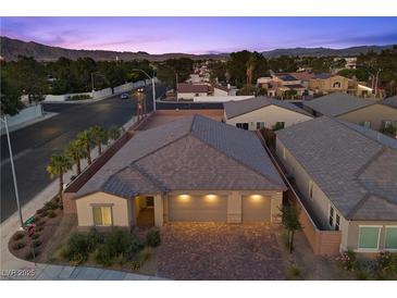 Charming single-Gathering home featuring a three-car garage and landscaped front yard with mature trees and palm trees at 3706 Etendre Ct, Las Vegas, NV 89121