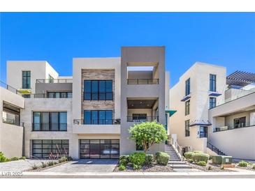 Modern three-story home boasts clean lines, large windows, two-car garage, and minimalist landscaping at 414 Tranquil Peak Ct, Henderson, NV 89012