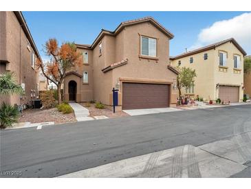 Inviting two-story home with a brown garage door, desert landscaping and neutral-toned stucco facade at 8152 Satin Carnation Ln, Las Vegas, NV 89166