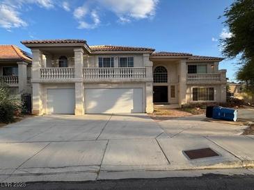 Two-story home featuring a double garage, balconies, and classic Mediterranean-style architecture at 9181 Ivory Beach Dr, Las Vegas, NV 89147