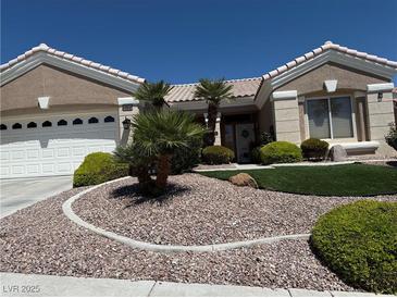 Charming single-story home featuring a well-maintained front yard with desert landscaping, green turf, and mature palm trees at 10832 Heritage Hills Dr, Las Vegas, NV 89134
