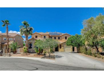 Charming two-story home featuring desert landscaping, mature trees, and a spacious driveway leading to a two-car garage at 6409 Sea Swallow St, North Las Vegas, NV 89084