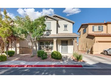 Charming two-story home featuring well-maintained landscaping and a welcoming front porch at 680 Moonlight Stroll St, Henderson, NV 89002